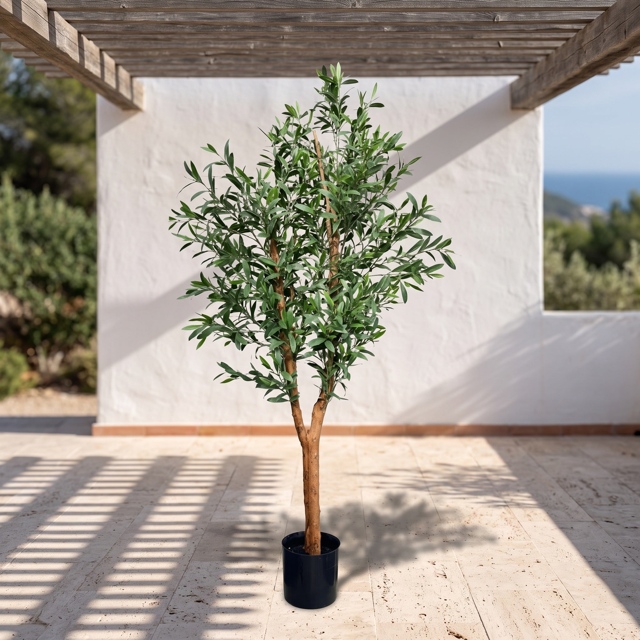 Kunst olijfboom 150 cm met hardhouten stam op een zonnig mediterraan terras onder een pergola